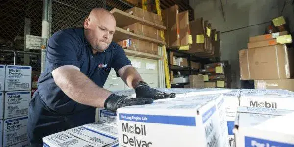 Man in warehouse organizing boxes.