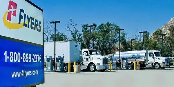 2 non-descript trucks at the pumps with the Flyers sign in foreground.